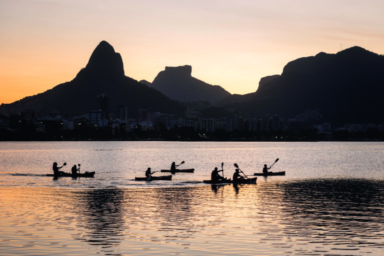 Pessoas remando na Lagoa Rodrigo de Freitas ao pôr do sol