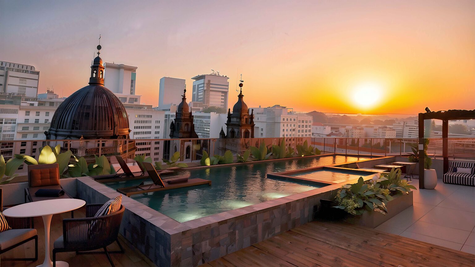 Piscina do rooftop ao pôr do sol, com a Candelária ao fundo