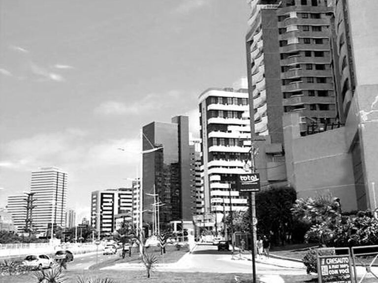 Avenida com edifícios altos, em preto e branco